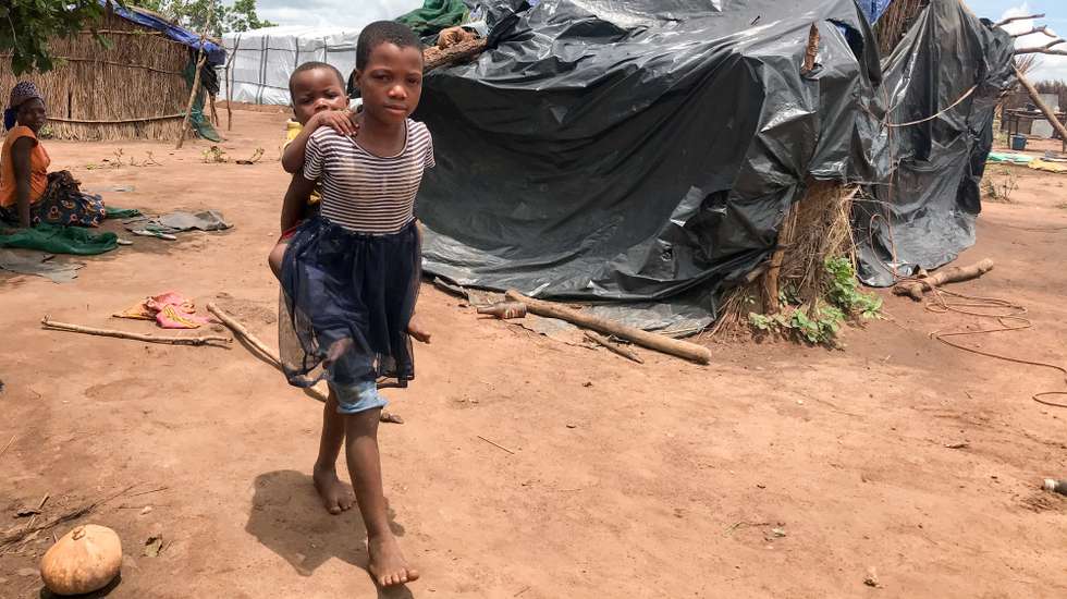 epa08968200 War displaced people from central Mozambique in the shelter center of Chibuto that was hit by the passage of cyclone Eloise last weekend, Gondola district, Manica province, Mozambique, 26 January 2021 (issued on 27 January 2021). After being forced to move due to attacks by former guerrillas, the precarious shelters where they lived at the resettlement site were partially destroyed by Cyclone Eloise.  EPA/ANDRE CATUEIRA