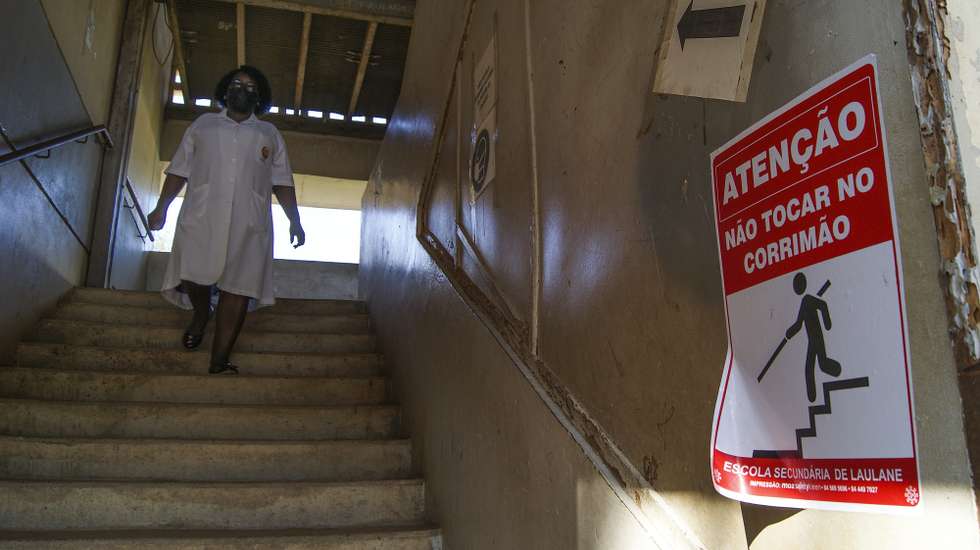 Um cartaz de informação no acesso às escadas de uma escola onde se lê "Atenção, Não Tocar no Corrimão", no primeiro dia do regresso às aulas devido à covid-19, em Maputo, Moçambique, 22 de março de 2021. Moçambique viveu em estado de emergência entre abril e setembro de 2020, vigorando desde então o estado de calamidade, designações legais para enquadrar diversas restrições com vista à prevenção da covid-19, que incluíram a suspensão das aulas. LUÍSA NHANTUMBO/LUSA