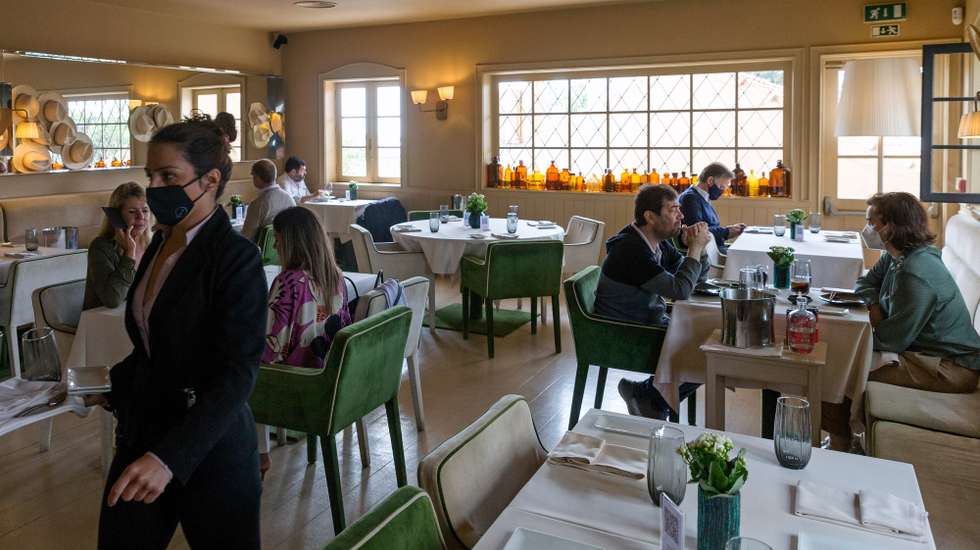 Clientes almoçam no interior do restaurante 'Wish', no dia em que entram em vigor novas medidas de desconfinamento, no Porto, 19 de abril de 2021. Passa a ser autorizada a abertura de restaurantes, cafés e pastelarias, mas com a restrição de lotação máxima a quatro pessoas ou seis pessoas em esplanadas e com horário até às 22:00 horas ou às 13:00 ao fim de semana. JOSÉ COELHO/LUSA