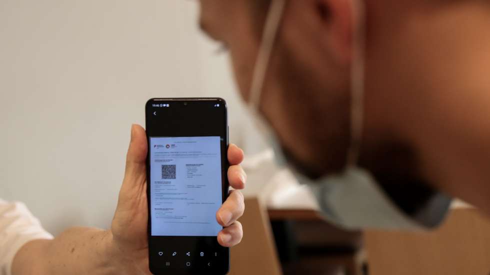 Cliente exibe o certificado digital à entrada de um restaurante em Lisboa, após o Governo decreta que os restaurantes em concelhos de risco elevado ou muito elevado – um total de 60 – passam a ter de exigir certificado digital ou teste negativo à covid-19 a partir das 19:00 de sexta-feira e aos fins de semana para refeições no interior, Lisboa, 10 de julho de 2021. As pessoas em esplanadas que precisarem de entrar nos restaurantes para acesso aos serviços comuns, como instalações sanitárias, ou para efetuarem pagamento, estão dispensadas de apresentar um teste negativo à covid-19 ou o certificado digital. MANUEL DE ALMEIDA/LUSA