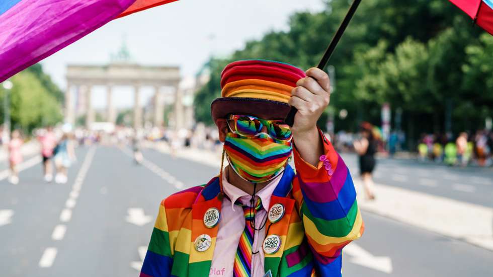 epa09362321 A participant dressed in rainbow colors waves a colorful veil attached to an umbrella in front of the Brandenburg Gate during the &#039;CSD Berlin 2021&#039; Christopher Street Day parade in Berlin, Germany, 24 July 2021. Due to the Coronavirus pandemic that causes the Covid-19 disease, this year&#039;s CSD demonstration only consists of five trucks and an expected crowd of some 20,000 participants. CSD is an annual European LGBTIQA* (lesbian, gay, bisexual, transgender, intersex, queer/questioning, asexual) celebration held in various cities across Europe for the rights of LGBTIQA* people.  EPA/CLEMENS BILAN