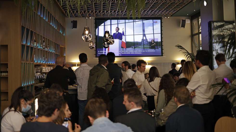 epa09340935 Bar customers watch French President Emmanuel Macron making a televised address to the nation to announce enhanced measures to fight the spread of Covid19 coronavirus, as France faces a possible resurgence of the pandemic, in Paris, France, 12 July 2021.  EPA/YOAN VALAT