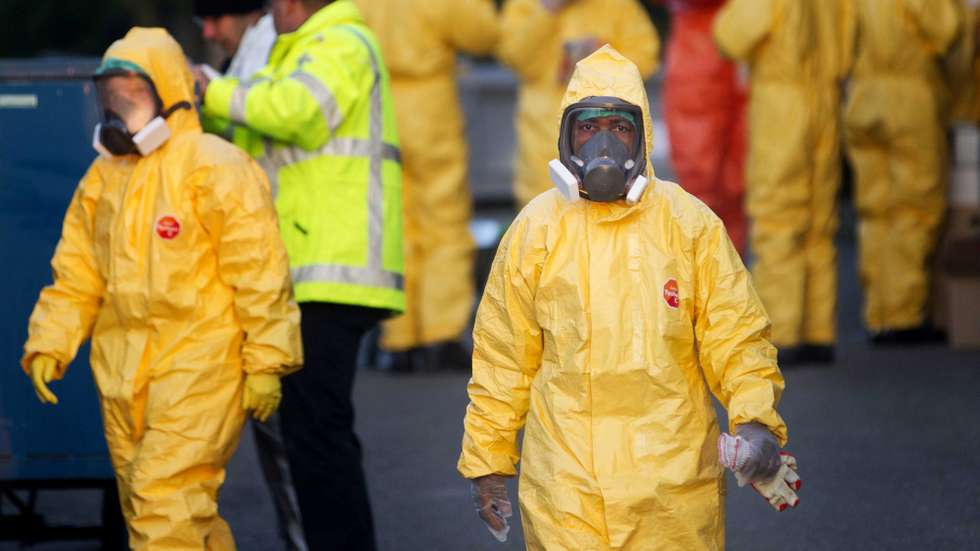 epa04497580 People in protective gear stand outside at a poultry farm in Ter Aar, The Netherlands, 21 November 2014. A form of bird flu was found on a second farm in the Netherlands. The Dutch authorities have banned the transport of poultry throughout the Netherlands after the detection of the virus.  EPA/JEROEN JUMELET