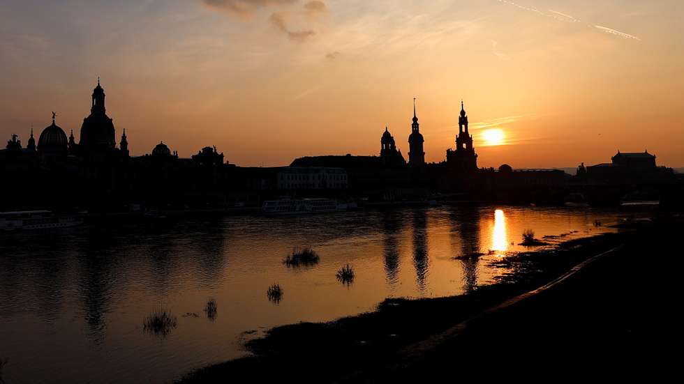 epa11187347 The Elbe river and city's skyline silhouetted against the setting sun, in central Dresden, Germany, 28 February 2024.  EPA/FILIP SINGER