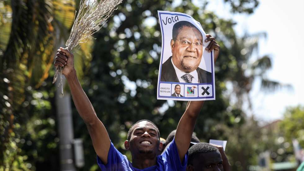 epa11645626 A supporter of the presidential candidate and president of the main opposition party Mozambican National Resistance (RENAMO) Ossufo Momade holds up his election campaign poster during a campaign event in Maputo, Mozambique, 06 October 2024. Mozambique is holding its seventh presidential and legislative elections on 09 October, as well as the fourth elections for provincial assemblies and governors. The current head of state, Filipe Nyusi, has reached the constitutional limit of two terms and is no longer running.  EPA/LUISA NHANTUMBO