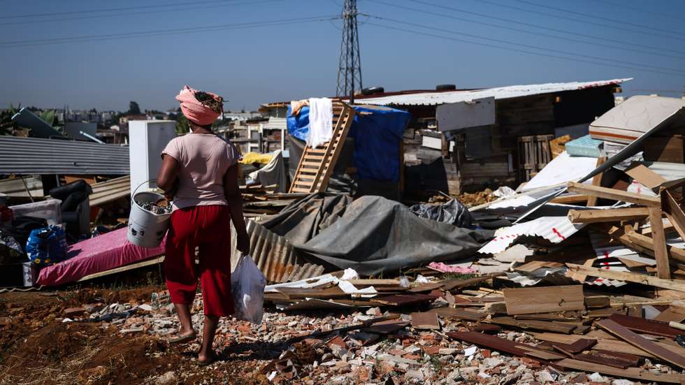 Uma moradora passa por destroços das habitações demolidas, durante o segundo dia da operação de demolição de habitações no bairro do Talude, uma ação da Câmara Municipal de Loures, em Loures, 15 de julho de 2025. O Tribunal Administrativo de Círculo de Lisboa decretou que a Câmara Municipal de Loures fica “impedida de executar o ato de demolição” de habitações no Bairro do Talude Militar, segundo um despacho de segunda-feira à noite consultado pela agência Lusa. RODRIGO ANTUNES/LUSA