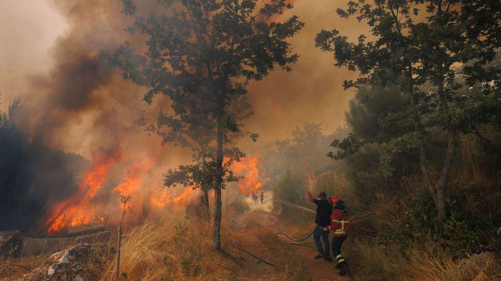 Um bombeiro e um popular durante o combate a um incêndio na Aldeia de Gontães, Vila Real, 4 de agosto de 2025. Pelas 16:30, mais de 2.200 operacionais e cerca de 710 meios de transporte, inclusive 19 meios aéreos, combatiam 63 incêndios rurais em Portugal continental, com destaque para os fogos em Vila Real e Celorico de Basto (distrito de Braga), segundo a Proteção Civil. PEDRO SARMENTO COSTA/LUSA