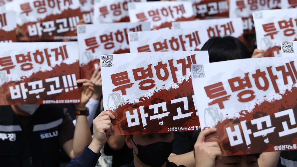 epa12908428 Samsung Electronics union members hold placards with the words ‘Transparent Change’ during a protest outside the company's semiconductor plant in Pyeongtaek, South Korea, 23 April 2026. The union has announced plans to launch an 18-day general strike from 21 May to 07 June, which could result in losses for the company of up to 30 trillion won (17.34 billion euros).  EPA/HAN MYUNG-GU
