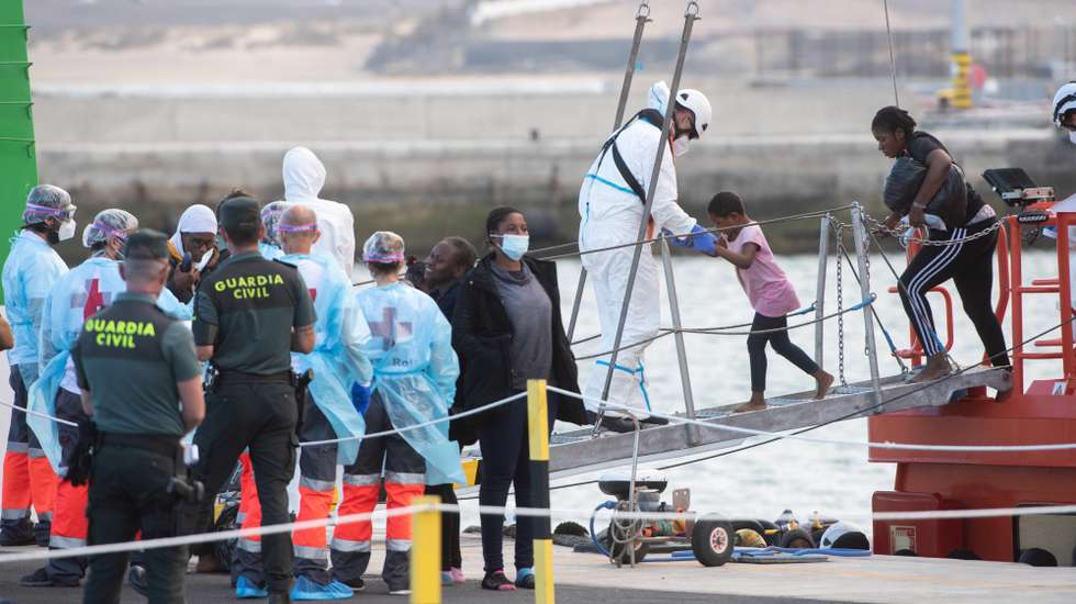 epa09294151 Red Cross and Canary Islands Health Service members take care of migrants rescued upon arrival at Puerto del Rosario port in Fuertventura, Canary Islands, Spain, 22 June 2021. A total of 105 SubSaharian migrants were rescued by Spanish Salvamento Maritimo when they were trying to reach the Spanish coast on board two small boats.  EPA/Carlos de Saa