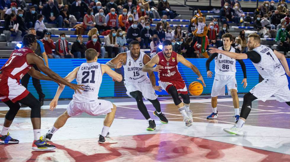 O jogador do Benfica Eduardo Francisco (C-D) disputa a bola com o jogador do Oliveirense Carlos Dotson (C-E), durante o jogo de basquetebol das meias-finais da Taça Hugo dos Santos, no Pavilhão Multiúsos de Sines, 22 de janeiro de 2022. TIAGO CANHOTO/LUSA