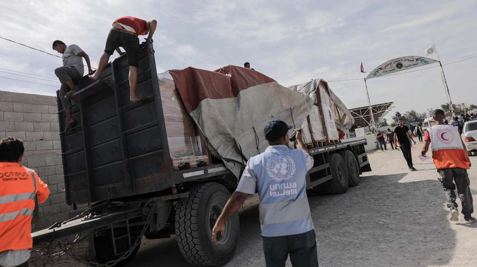 epa10930605 Personnel from the Palestine Red Crescent Society unload a truck carrying humanitarian aid for Gaza Strip after it enters from Egypt in Rafah, 21 October 2023. As Egypt is to host, on 21 October, an international summit about Gaza, and following the negotiations between Egypt, the US, and Israel to allow relief aid to enter the Gaza Strip, some 20 aid trucks carrying food, water, and medicine have been allowed into the Gaza Strip through the Rafah land crossing on 21 October. The move comes after days during which trucks were blocked on the Egyptian side of the Rafah border crossing. Egypt's Foreign Ministry had requested that the Isareli strikes on the area near the Gaza side of the border crossing stop, in order to allow the passage of the aid.  EPA/HAITHAM IMAD