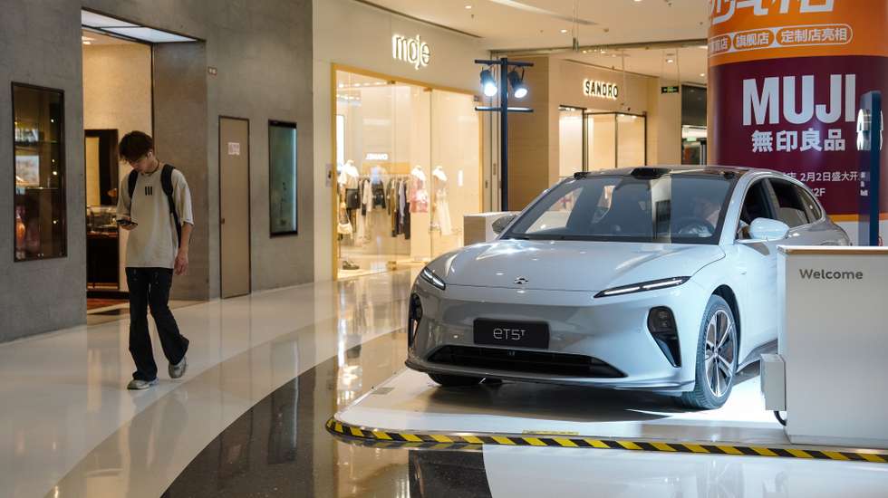 epa11407063 A man walks beside a NIO ET5 electric car on display in a shopping mall in Beijing, China, 13 June 2024. Beijing urges the European Union to reconsider tariffs on Chinese electric vehicles and to stop going further in what they say is the 'wrong direction' to protect its auto industry from competition, according to China's state news agency Xinhua. China said it would take measures to safeguard its interests after the European Commission announced on 12 June it would impose extra duties of up to 38.1 percent on imported Chinese electric vehicles from July 2024.  EPA/WU HAO