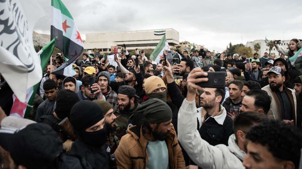 epa11794995 People react as Syrian opposition fighters hold a military parade in Damascus, Syria, 27 December 2024. Members of Hay'at Tahrir al-Sham (HTS) began marching from abbasieen Square, passing through some of the Damascene neighborhoods, and arrived at Umayyad Square in a parade organized to send a message of strength and reassurance to the people, according to HTS.