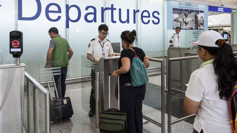 epa07772454 Passengers have their passport checked at departure gates in Hong Kong International Airport, Hong Kong, China, 14 August 2019. Flights were departing largely on schedule a day after pro-democracy protesters caused chaos with a disruptive sit-in that paralyzed the busy transport hub. The Airport Authority said it had been granted an injunction order to ban anyone from illegally or intentionally disrupting the normal usage of the airport.  EPA/MIGUEL CANDELA