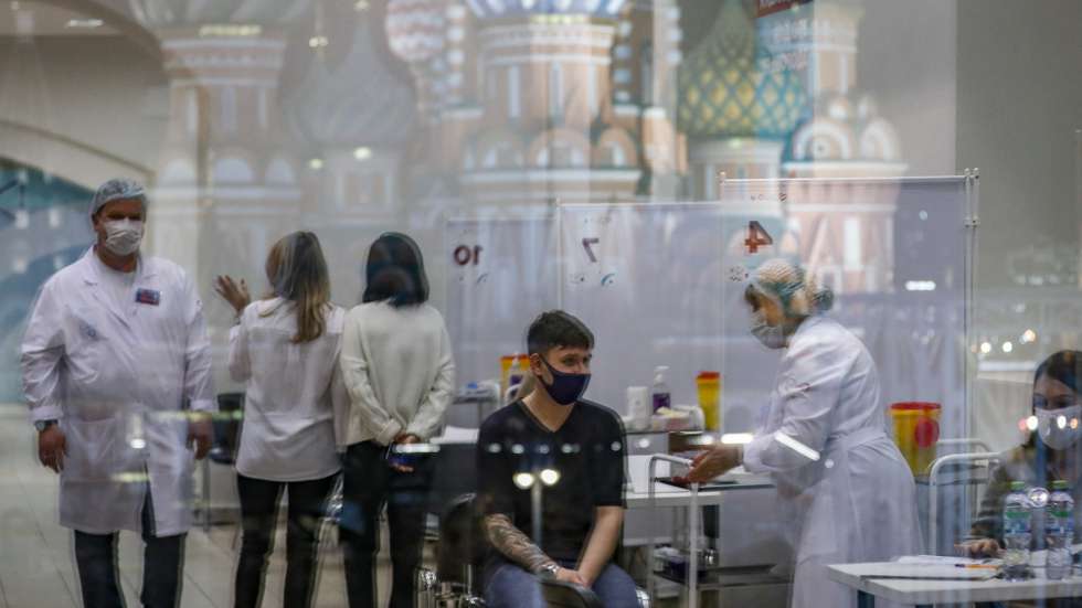 epa09551070 St. Basil's Cathedral is visible in the window of Vaccination point at the State Department Store GUM in Moscow, Russia, 28 October 2021. Russian authorities approved non-working week from 28 October to 07 November in Russia to curb the fast spreading of coronavirus infection. Restrictions are also put in place during the non-working week, such as the closure of shopping malls, beauty salons, fitness centers and car services but pharmacies, hospitals and food stores will stay open.  EPA/YURI KOCHETKOV