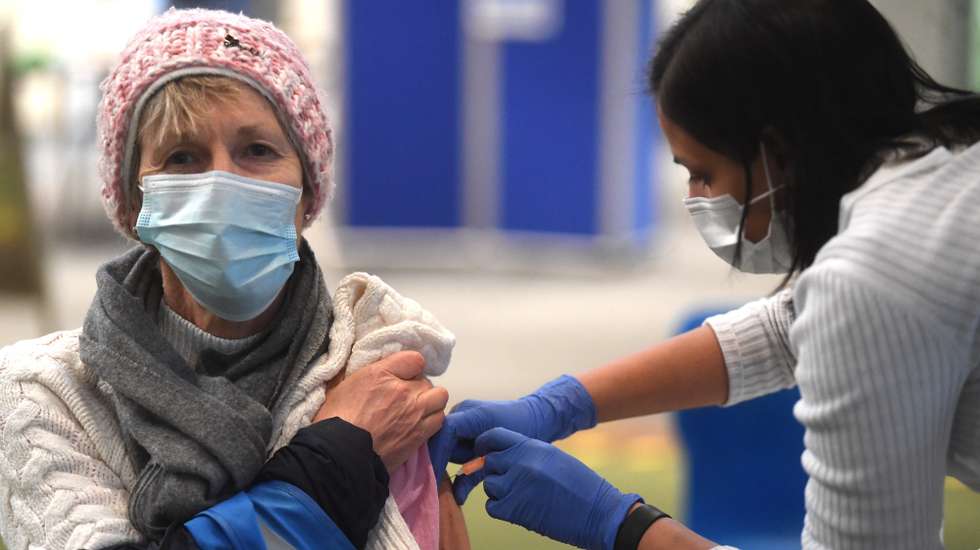 epa09007235 A woman receives the AstraZeneca Covid19 vaccine at an NHS vaccination centre in Ealing, west London, Britain, 12 February, 2021. UK is close to completing first step of the vaccination programme, with 13.5m people having had a first jab according to NHS England.  EPA/NEIL HALL