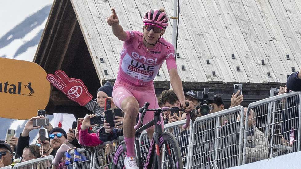 epa11353678 Slovenian rider Tadej Pogacar of UAE Team Emirates celebrates after crossing the finish line to win the 15th stage of the 107th Giro d'Italia 2024 cycling tour, over 222 km from Manerba del Garda to Livigno, Italy, 19 May 2024.  EPA/LUCA ZENNARO