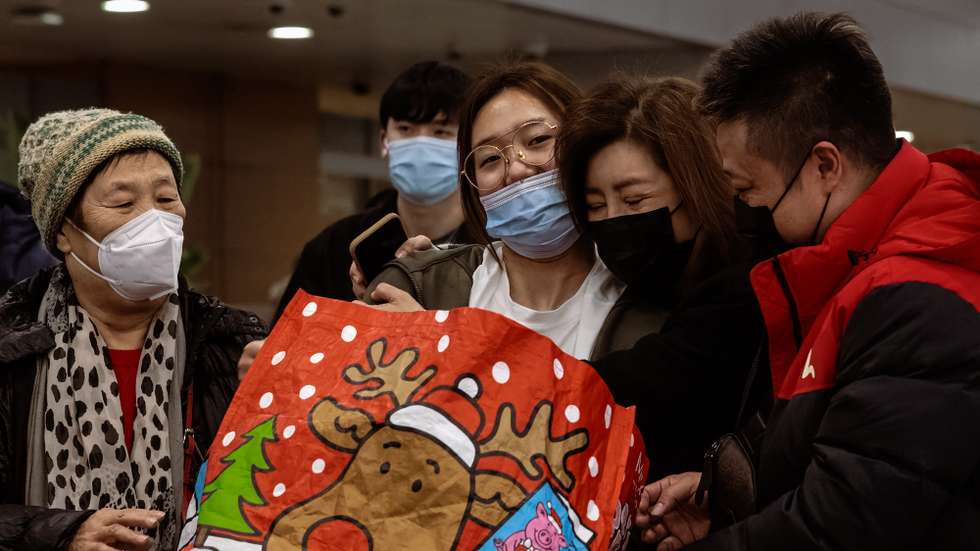 epa10395517 A family greets a woman (C) who landed with international flight on the Pudong International Airport, in Shanghai, China, 08 January 2023. China has reopened its borders and no longer requires quarantine for inbound travellers. The country's National Health Commission (NHC) has downgraded the management of COVID-19 from Class A to Class B as part of measures in reopening the country.  EPA/ALEX PLAVEVSKI