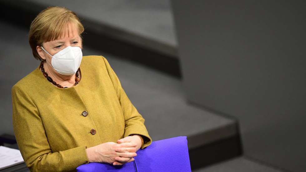 epa08970477 German Chancellor Angela Merkel looks on as she stands behind her seat prior a government declaration on the annual economic report 2021 in the German parliament Bundestag in Berlin, Germany, 28 January 2021.  EPA/CLEMENS BILAN