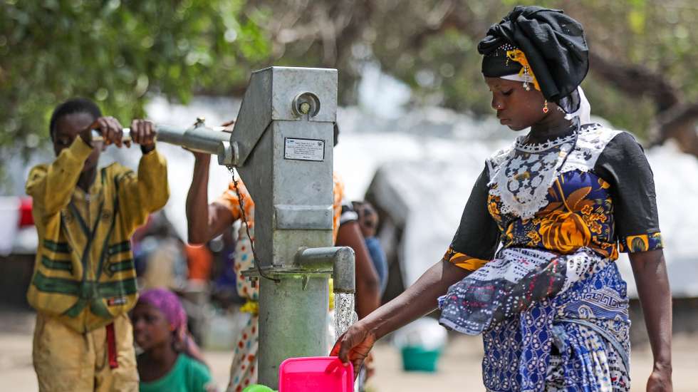 A mother and is son take water from a fountain in the 25 June relocated camp in Belibize, near Metuge, northern Mozambique, 10 April 2021. The violence unleashed more than three years ago in Cabo Delgado province escalated again about two weeks ago, when armed groups first attacked the town of Palma. JOAO RELVAS/LUSA