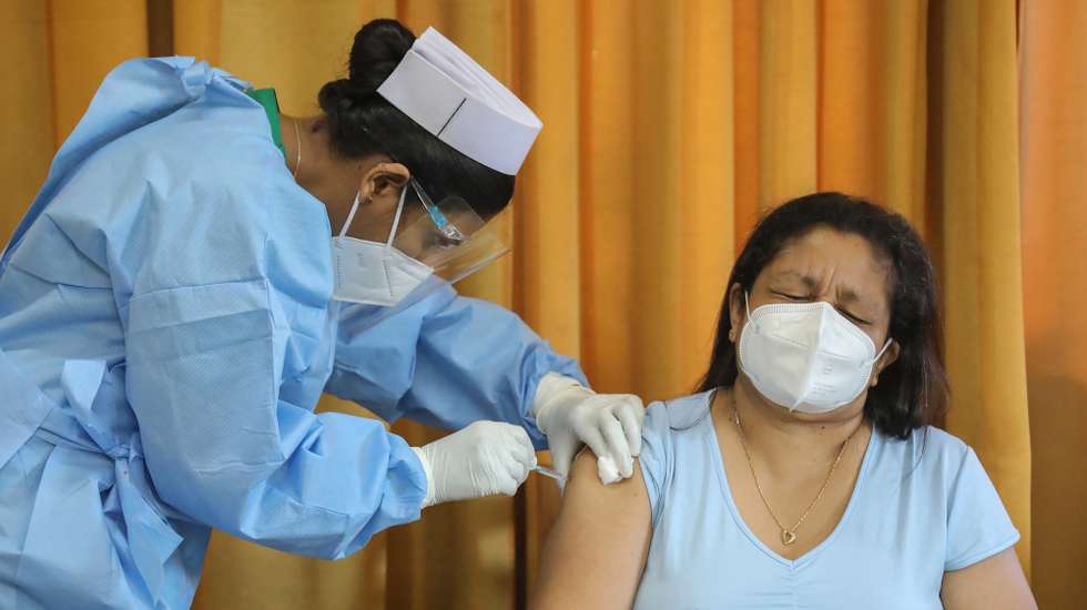 epa08976612 A health worker received the first dose of the Oxford-AstraZeneca COVID-19 vaccine at the Police Hospital in Colombo, Sri Lanka, 31 January 2021. Sri Lankan health authorities started the COVID-19 vaccination drive for frontline workers on 29 January, after receiving 500,000 doses of the Oxford-AstraZeneca COVID-19 vaccine from neighboring India.  EPA/CHAMILA KARUNARATHNE