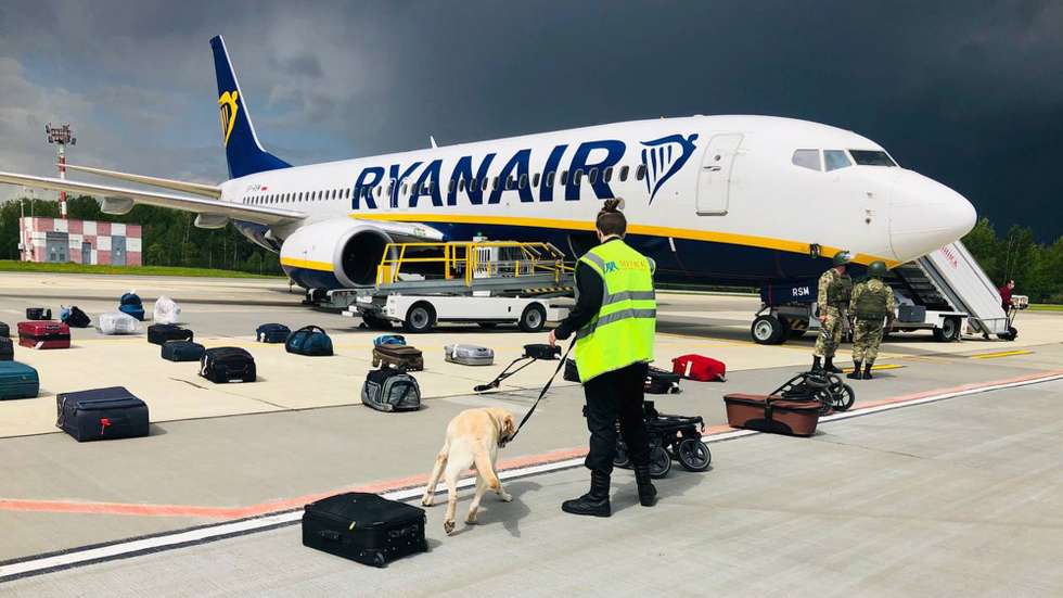 epa09224989 A handout photo made available by ONLINER.BY shows security with a sniffer dog checking the luggage of passengers in front of Ryanair Boeing 737-8AS (flight FR4978), carrying opposition figure Roman Protasevich, in Minsk, Belarus, 23 May 2021 (issued 24 May 2021). A Ryanair flight from Athens, Greece to Vilnius, Lithuania, with Belarus' opposition journalist Roman Protasevich onboard, was diverted and forced to land in Minsk on 23 May 2021, after an alleged bomb threat. Protasevich was detained by Belarusian Police after landing, as Belarusian Human Rights Center 'Viasna' reports, Lithuanian President Gitanas Nauseda demanded the immediate release of Protasevich.  EPA/ONLINER.BY HANDOUT -- BEST QUALITY AVAILABLE -- HANDOUT EDITORIAL USE ONLY/NO SALES