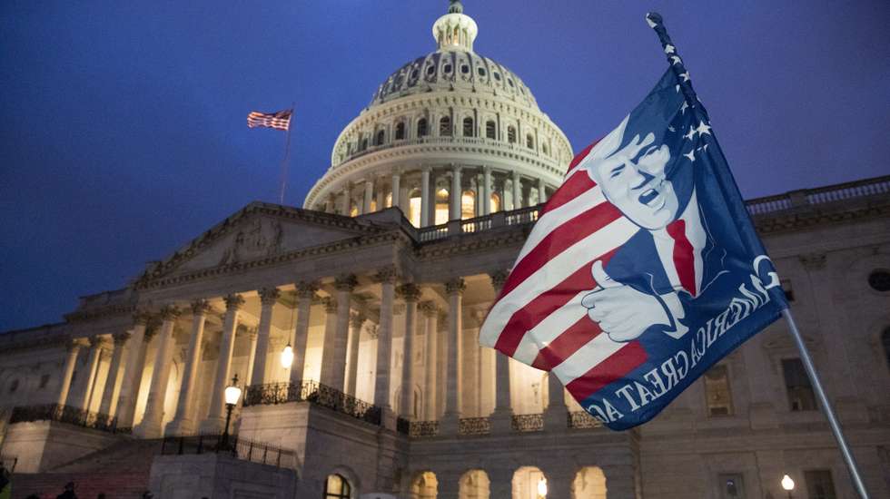 epa08923726 A flag is left by a Trump supporter at the US Capitol at dusk as a curfew begins after pro-Trump protesters stormed the grounds leading to chaos, in Washington, DC, USA, 06 January 2021. Various groups of Trump supporters have broken into the US Capitol and rioted as Congress prepares to meet and certify the results of the 2020 US Presidential election.  EPA/MICHAEL REYNOLDS