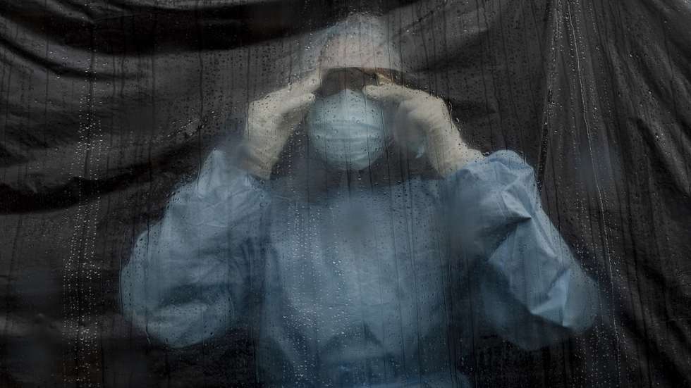 epa09245696 A health worker Simran Thapa looks outside while taking care of Covid-19 patient during a rainfall at Ratna Rajya community Isolation Center in Kathmandu, Nepal, 28 May 2021 (Issued  03 June 2021). According to a Nepalese Health Ministry press release on 03 June 2021, the numbers of the infected reached 571 thousands and 7,555 deaths. As the COVID-19 numbers increased and hospitals became overwhelmed in Nepal, more isolation centers started to be set up as an alternative. Isolation centers are mostly hosted and run by social and business organizations, as well as political parties, youth groups, and the Nepalese army. They accept patients from all age groups and backgrounds. Ratna Rajya community Isolation Center can house up to 40 COVID-19 patients.   EPA/NARENDRA SHRESTHA  ATTENTION: This Image is part of a PHOTO SET