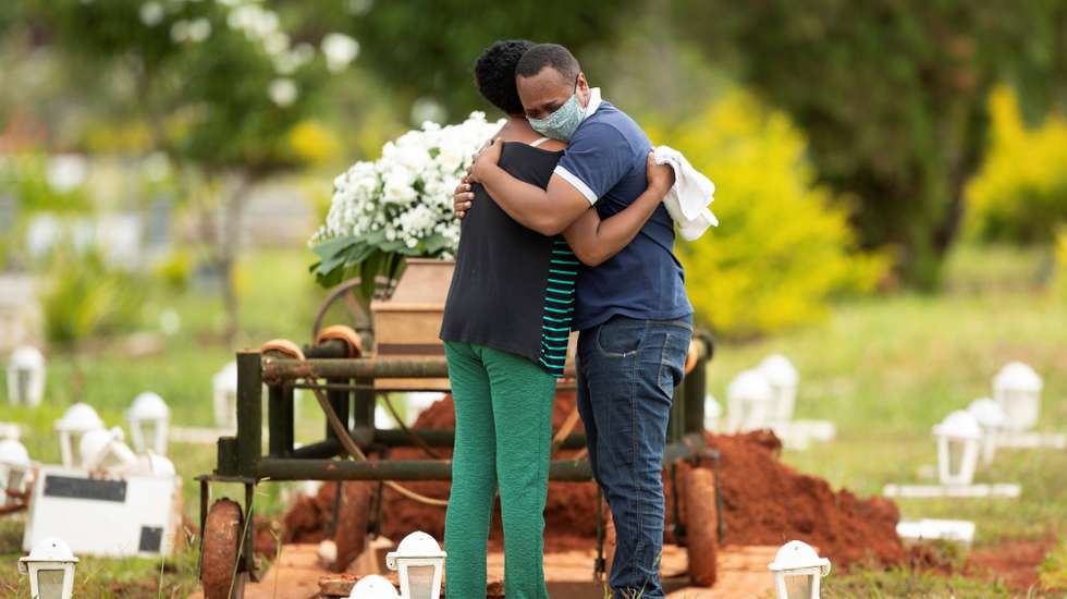 epa09168353 A group of people attend the burial of a loved one who was a victim of covid-19 at the Campo da EsperanÃ§a cemetery, in the city of Brasilia, Brazil, 29 April 2021. Brazil surpassed on 29 April 400,000 deaths from covid-19 since the start of the pandemic just over a year ago, according to a media consortium based on data from regional governments.  EPA/Joedson Alves