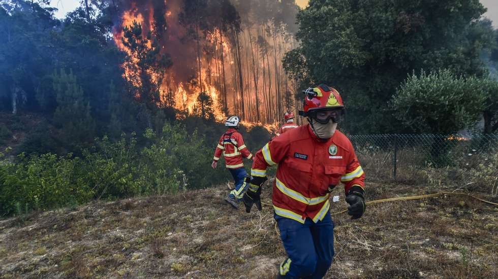 Elementos dos bombeiros durante o combate ao incêndio florestal na aldeia do Lavradio, Ourém, 13 de julho de 2022. Dezasseis dos 18 distritos de Portugal continental estão hoje sob aviso vermelho, o mais grave, devido ao tempo quente, com mais de uma centena de concelhos em perigo máximo de incêndio rural. NUNO ANDRÉ FERREIRA/LUSA