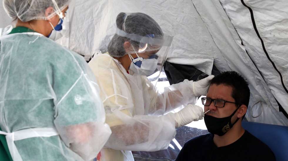 epa08862623 Medical personnel take tests for coronavirus in Sao Goncalo, Rio de Janeiro state, Brazil, 04 December 2020. The state of Rio de Janeiro began on the same day the massive taking of covid-19 tests with the aim of carrying out up to 1,500 daily tests, at a time when the pandemic is once again taking force in Rio.  EPA/Fabio Motta