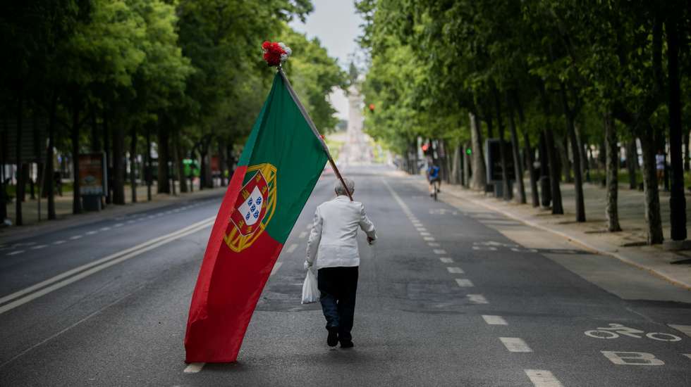 CONJUNTO DE 30 FOTOGRAFIAS SOBRE UM ANO DE ESTADO DE EMERGÊNCIA: 16-30: Foto datada de 25/04/2020: Um homem com uma bandeira de Portugal sobe a Avenida da Liberdade em Lisboa, por volta das 15 horas, altura em que anualmente se realiza um desfile comemorativo do 25 de abril de 1974 e que, devido à pandemia da covid-19, não pode ter lugar, em Lisboa, 25 de abril de 2020. Os 46 anos do 25 de Abril estão a ser hoje celebrados de forma diferente em Portugal, com uma sessão solene reduzida no parlamento, sem o tradicional desfile e com um apelo para que os portugueses cantem a ‘Grândola' à janela. JOSÉ SENA GOULÃO/LUSA