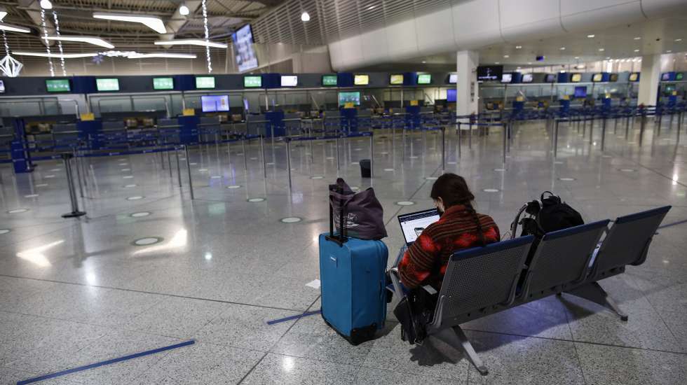 epa08839507 A commuter stands in the empty departure terminal of Eleftherios Venizelos International Airport of Athens, during the second lockdown of the country, in Spata, near Athens, Greece, 24 November 2020. Greece is currently under a nationwide lockdown that went into effect on November 7 and will remain effective through November 30, to prevent the spread of the coronavirus Covid-19 pandemic.  EPA/YANNIS KOLESIDIS