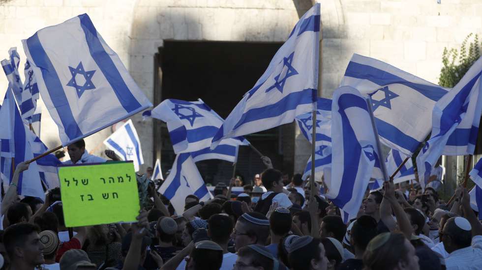 epa09274157 Members of Israeli right-wing groups taking part in the 'Flag March' wave Israeli flags next to Damascus gate of Jerusalem's Old City, 15 June 2021. Media reports state that more than 2,500 Israeli police were deployed to secure the march and the Israeli army is preparing for the possibility of another escalation with Gaza.  EPA/ATEF SAFADI