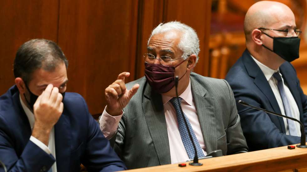O primeiro-ministro, António Costa (C), ladeado pelo secretário de Estado dos Assuntos Parlamentares, Duarte Cordeiro (E), e pelo ministro das Finanças, João Leão (D), reage durante a sessão plenária para a votação do Orçamento do Estado 2021 (OE2021), na Assembleia da República, em Lisboa, 26 de novembro de 2020. MANUEL DE ALMEIDA/LUSA