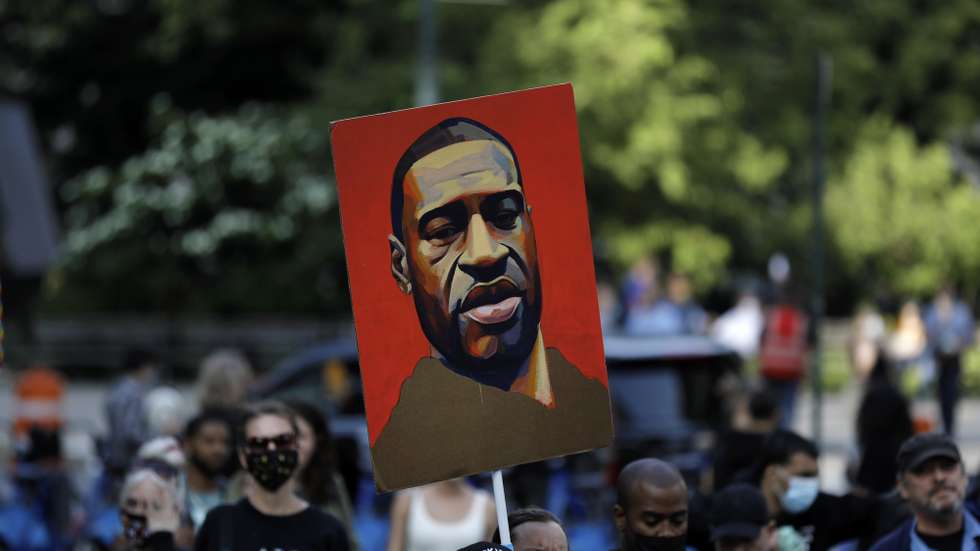 epa09227919 A demonstrator carries a drawing of George Floyd at the one year anniversary protest of George Floyd's death in lower Manhattan in New York, New York, USA, 25 May 2021. Exactly one year has passed since George Floyd was killed in Minneapolis, Minnesota, after now-convicted former police officer Derek Chauvin kneeled on Floyd's neck for nine minutes, twenty-nine seconds. The year has seen a protest movement which became global and has impacted political elections, police tactics and budgets as well as investigations and prosecutions of similar cases.  EPA/Peter Foley