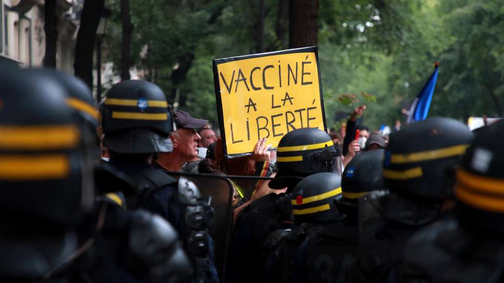 epa09383069 A protester holds a poster reading 'Vaccinated with freedom' during a demonstration against the COVID-19 health pass which grants vaccinated individuals greater ease of access to venues in France, in Paris, France, 31 July 2021. Anti-vaxxers, joined by the anti-government 'yellow vest' movement, are demonstrating across France for the third consecutive week in objection to the health pass, which is now mandatory for people to  visit leisure and cultural venues.  EPA/CHRISTOPHE PETIT TESSON