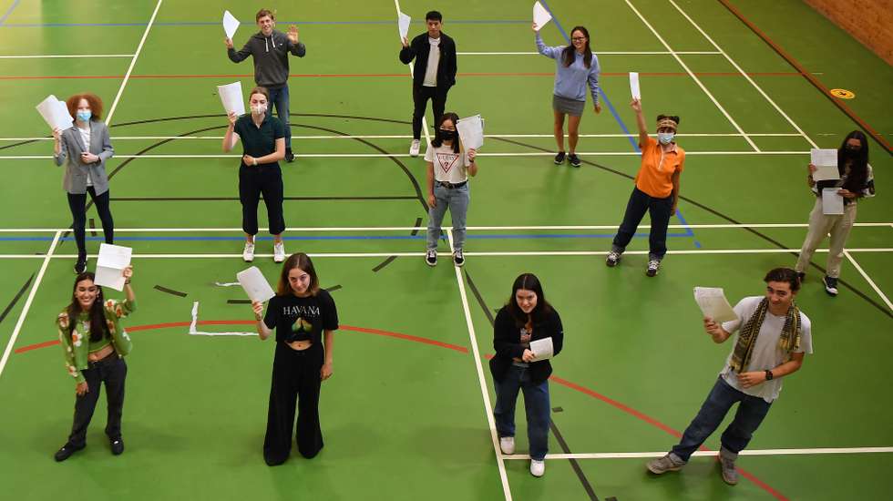 epa08614344 Secondary school students hold their GCSE results at Kingsdale Foundation school in southern London, Britain, 20 August 2020. The British government has made a U-turn on how A-levels and GCSE results are graded following recent student protests.  Some forty percent of students across England had previously received downgraded results.  EPA/ANDY RAIN