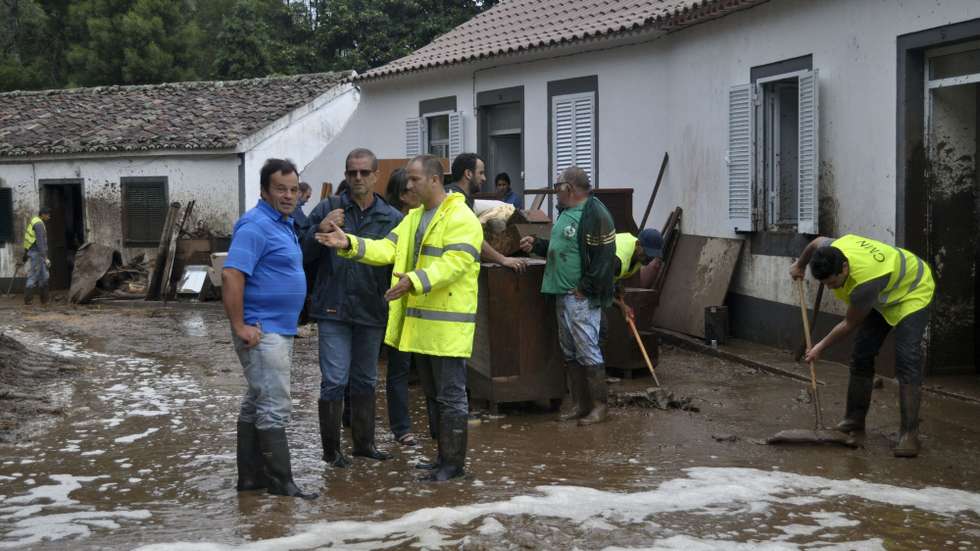Funcionários camarários limpam uma rua que ficou inundada devido ao mau tempo que está afetar os grupos central e oriental, que estão sob aviso vermelho, no Lugar da pedreira, Concelho do Nordeste, São Miguel, Açores, 03 de setembro de 2015. A Proteção Civil dos Açores alertou hoje para a continuação de mau tempo em todas as nove ilhas açorianas, que passam a estar sob aviso laranja da meteorologia devido à previsão de chuva. PEDRO MONTEIRO/LUSA