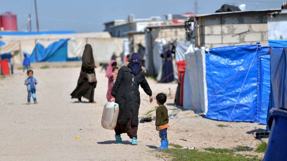 epa07393580 Displaced women walk at Roj refugees camp in Hasakah, northeast of Syria, 24 February 2019. The camp which is controlled by the US-backed Syrian Democratic Forces (SDF) houses over 300 families, most of them are wives and children of Islamic state (IS) fighters among them foreigners who arrived in the camp following the defeat of Islamic State group in its last strongholds in eastern Syria.  EPA/MURTAJA LATEEF