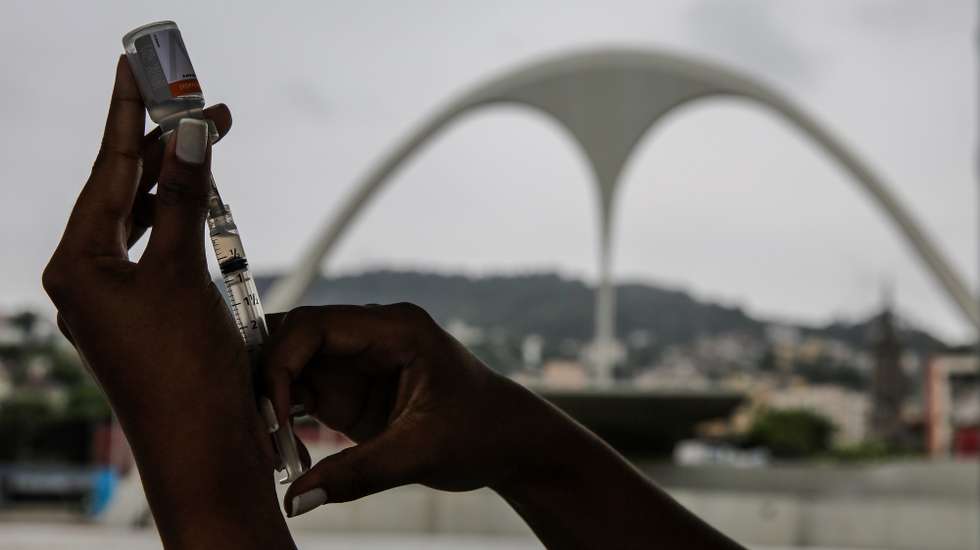 epa08991983 A health worker prepares a shot of Sinovac vaccine in a vaccination center placed at the 'Samba's Passarela', in Rio de Janeiro, Brazil, 06 February 2021. The sambadrome has been turned into a covid-19 vaccination place for older adults.  EPA/ANTONIO LACERDA
