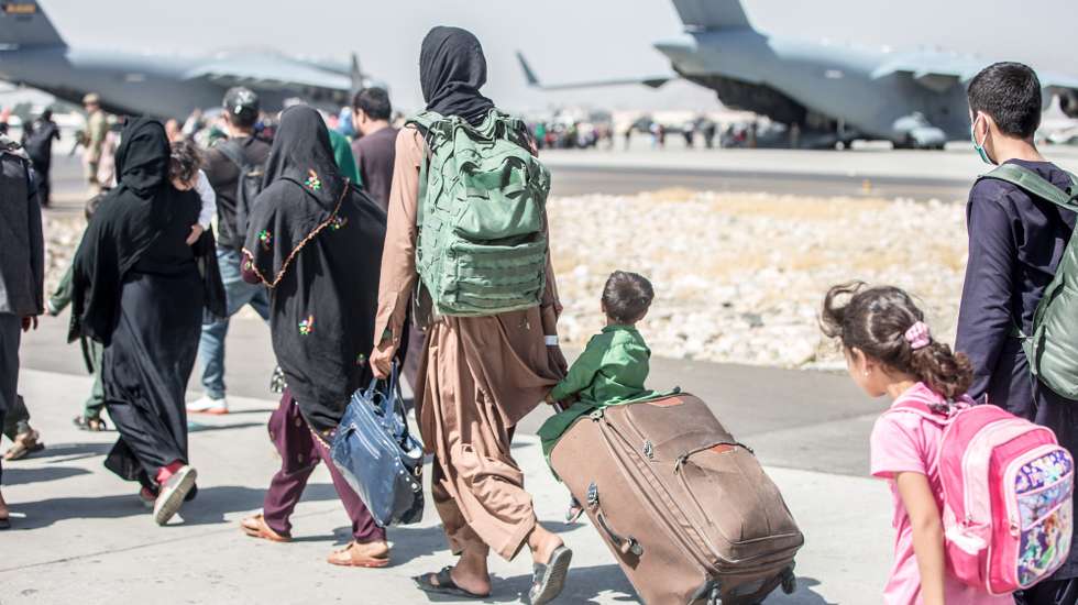 epa09427968 A handout photo made available by the US Marine Corps via DVIDS showing a child looks at the aircraft as he is strolled towards his flight during an evacuation at Hamid Karzai International Airport, Kabul, Afghanistan, 24 August 2021. US service members are assisting the Department of State with an orderly drawdown of designated personnel in Afghanistan. EPA/Sgt. Samuel Ruiz / US Marine Corps via DVIDS / HANDOUT ReleasedMaj. John RigsbeeU.S. Central Command Public AffairsJohn.j.rigsbee.mil@mail.mil(813) 529-0214via DVIDS HANDOUT EDITORIAL USE ONLY/NO SALES HANDOUT EDITORIAL USE ONLY/NO SALES