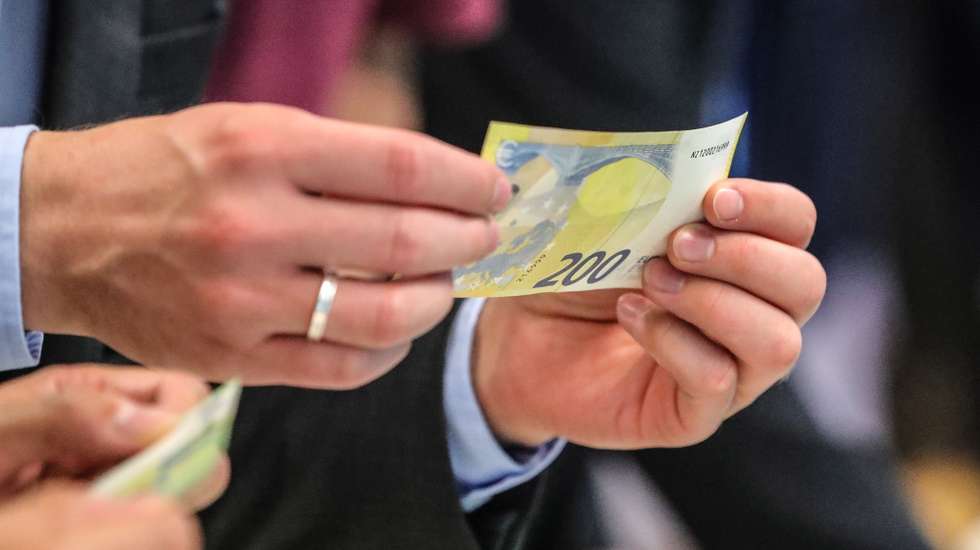 epa07027158 Visitors inspect new euro banknotes during the unveiling of the 100 and 200 euro banknotes at the European Central Bank (ECB) in Frankfurt am Main, Germany, 17 September 2018. The new 100 and 200 euro banknotes, part of the Europa series banknotes, will enter into circulation on 28 May 2019.  EPA/ARMANDO BABANI