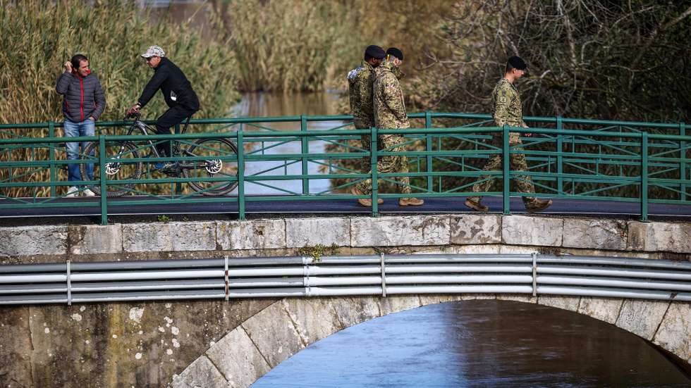 Civis e militares observam as águas do Rio Tejo na zona da Azambuja, 8 de fevereiro de 2026. Treze pessoas morreram em Portugal desde a semana passada como resultado das tempestades Kristin e Leonardo, que também provocaram centenas de feridos e desalojados. ANDRÉ KOSTERS/LUSA