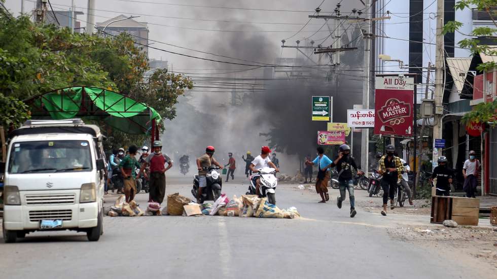 epa09087744 People flee during a protest against the military coup in Mandalay, Myanmar, 21 March 2021. Anti-coup protests continued despite the intensifying violent crackdowns on demonstrators by security forces.  EPA/STRINGER