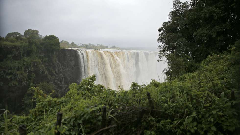 epa08249859 A general view towards the Victoria Falls, Zimbabwe, 26 February 2020. This time of the year the falls are at their peak and generate mists that can be seen from more than 20 kilometers away. The mist also sustains a rain forest-like ecosystem adjacent to the falls. As much as 540 million cubic meters of water fall over the edge every single minute.  EPA/AARON UFUMELI