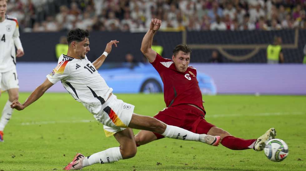 epa11592300 Aleksandar Pavlovic of Germany (L) in action against Willi Orban of Hungary (R)  to score the 4-0 goal during the UEFA Nations League group C soccer match between Germany and Hungary in Duesseldorf, Germany, 07 September 2024.  EPA/CHRISTOPHER NEUNDORF