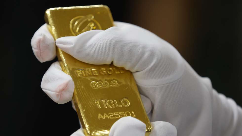 epa12062283 A Bank of Thailand staff member checks the authenticity of a gold bar after receiving the donation, during the handover ceremony at the Bank of Thailand in Bangkok, Thailand, 29 April 2025. The Bank of Thailand received a 10-kilogram gold bar donated by followers of Buddhist monk Luangta Maha Bua to support national reserves.  EPA/NARONG SANGNAK