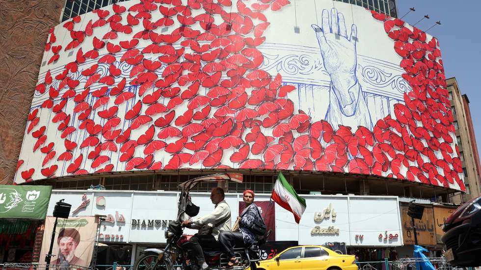 epa13108068 Iranians ride a motorbike past a large-scale billboard displayed on a building at Valiasr Square, in Tehran, Iran, 13 July 2026. In an official written statement on 11 July, Iran's new Supreme Leader, Ayatollah Mojtaba Khamenei, vowed retaliation for the killing of his father and predecessor, Ayatollah Ali Khamenei.  EPA/ABEDIN TAHERKENAREH RESTRICTIONS: NO Access Israel Media/Persian Language TV Stations Outside Iran/Strictly No Access BBC Persian/VOA Persian/Manoto TV/Iran International TV. (As mandated by Iran's Directorate General for Foreign Media) -- RESTRICTIONS: ISRAEL OUT - NO ACCESS ISRAEL MEDIA/PERSIAN LANGUAGE TV STATIONS OUTSIDE IRAN/STRICTLY NO ACCESS BBC PERSIAN/VOA PERSIAN/MANOTO TV/IRAN INTERNATIONAL TV