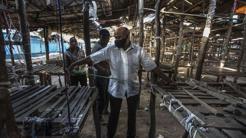 Técnicos do Conselho Autárquico de Maputo delimitam novos espaços para os vendedores do mercado do Xipamanine, uma medida que vai servir para garantir o distanciamento social devido à covid-19, em Maputo, Moçambique, 15 de junho de 2020. No âmbito das medidas de prevenção contra o novo coronavírus, o Conselho Autárquico decidiu encerrar temporariamente os 63 mercados da capital moçambicana e o Xipamanine é o primeiro. (ACOMPANHA TEXTO). RICARDO FRANCO/LUSA